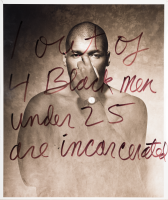 Image of a man black man with his hand covering his face. Handwritten text overlaying the image says: 1 out of 4 Black men under 25 are incarcerated. 